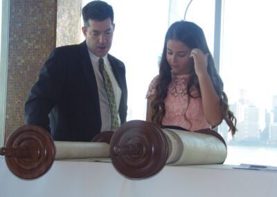 A Bat Mitzvah girl standing next to Rabbi Ron Broden at her ceremony.